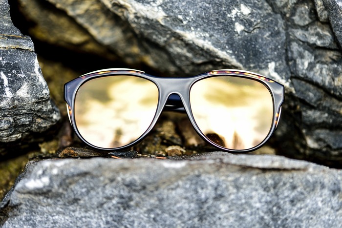 солнцезащитные очки с зеркальными линзами на каменном фоне